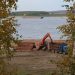 a crane is working on a pile of logs